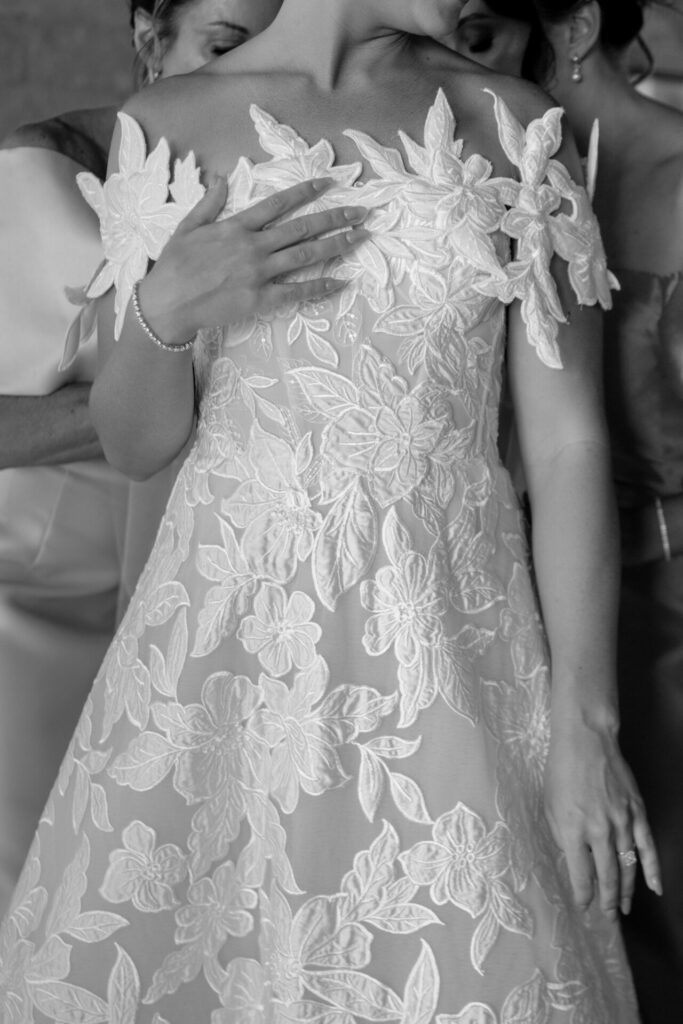 Bride in Mira Zwillinger gown, attendants assist closely.