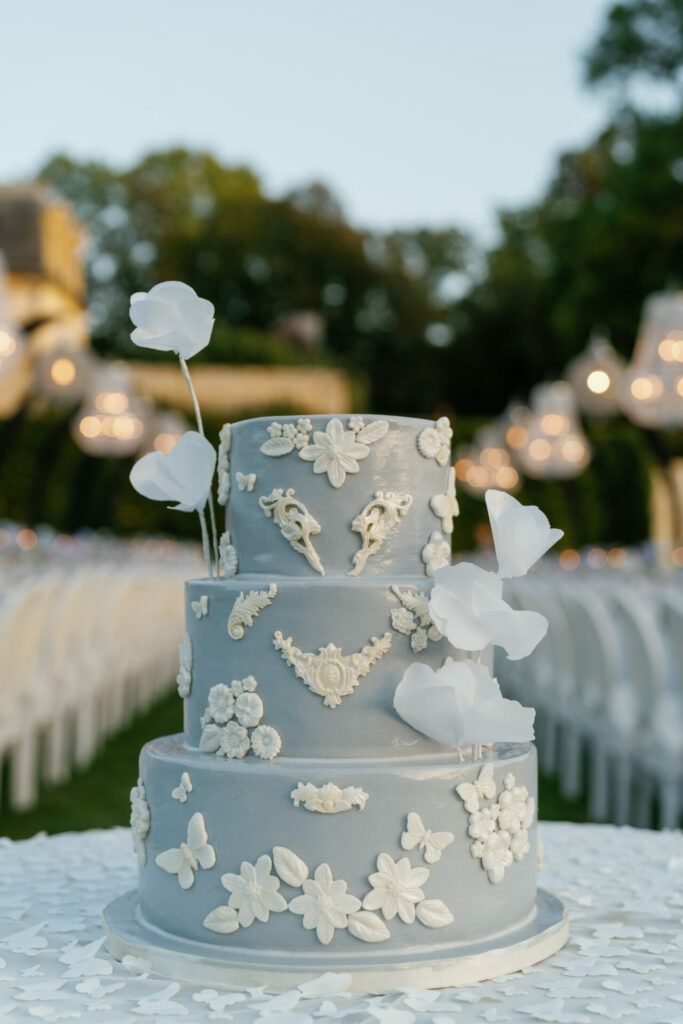 Light blue three-tier cake with white flowers and butterflies.