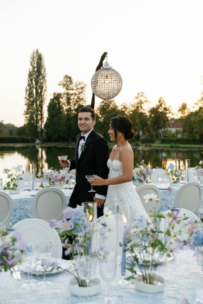 Katya Ruiz and groom stroll by lake at sunset.