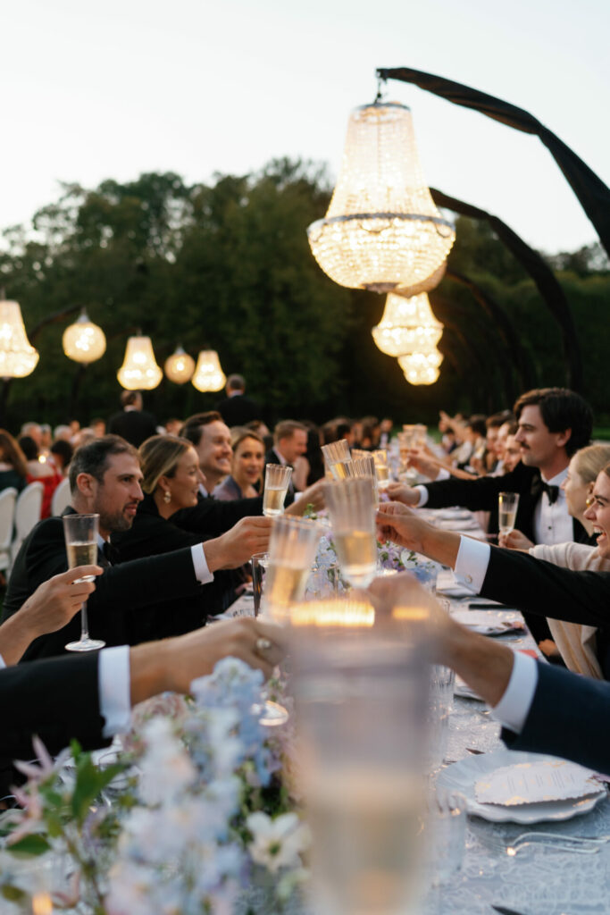 Katya Ruiz toasts in her gown at elegant outdoor table.