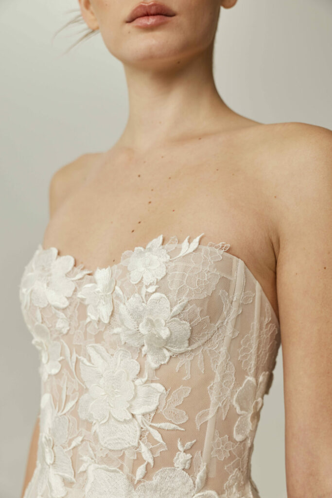 Woman in strapless nude dress with white lace.