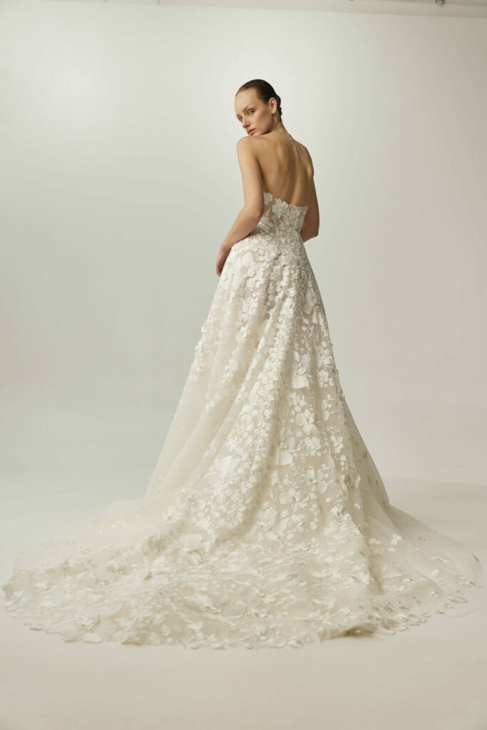 Woman in white strapless wedding gown, back turned.