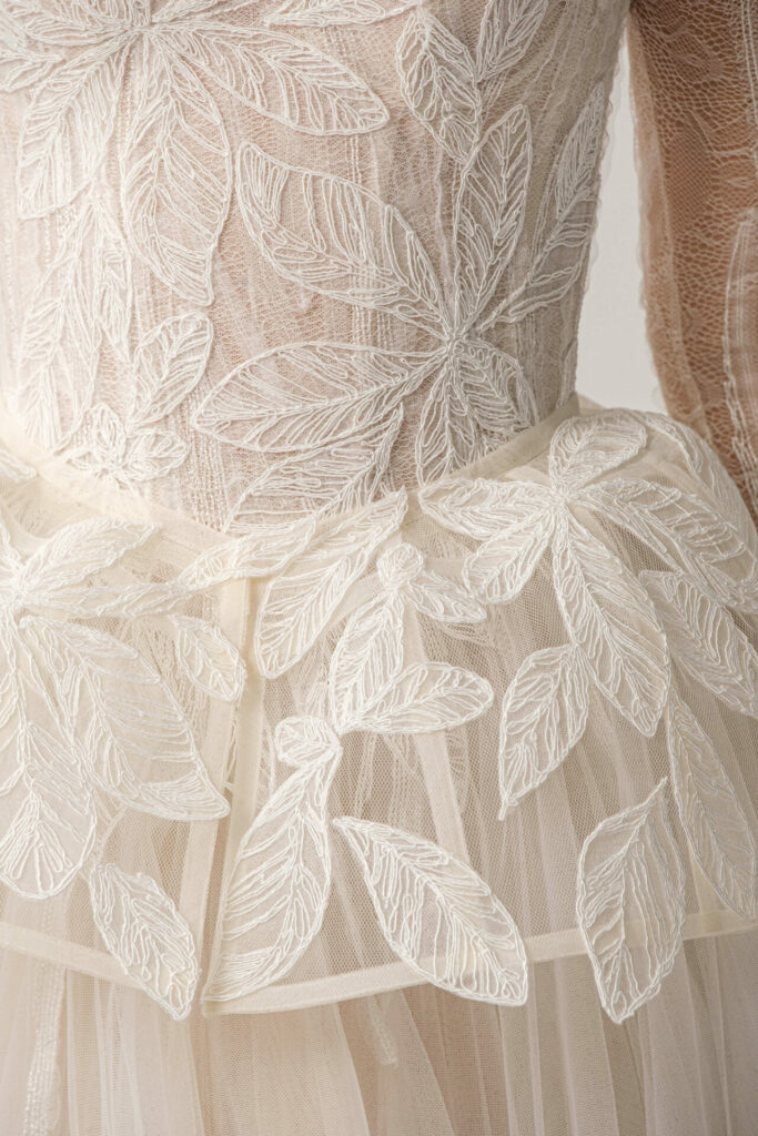 Sheer cream fabric with embroidered leaf pattern.