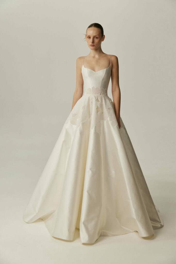 Woman in ivory ballgown with floral skirt.