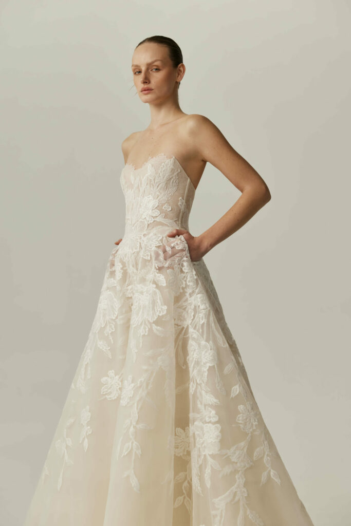 Woman in ivory strapless gown with pockets.