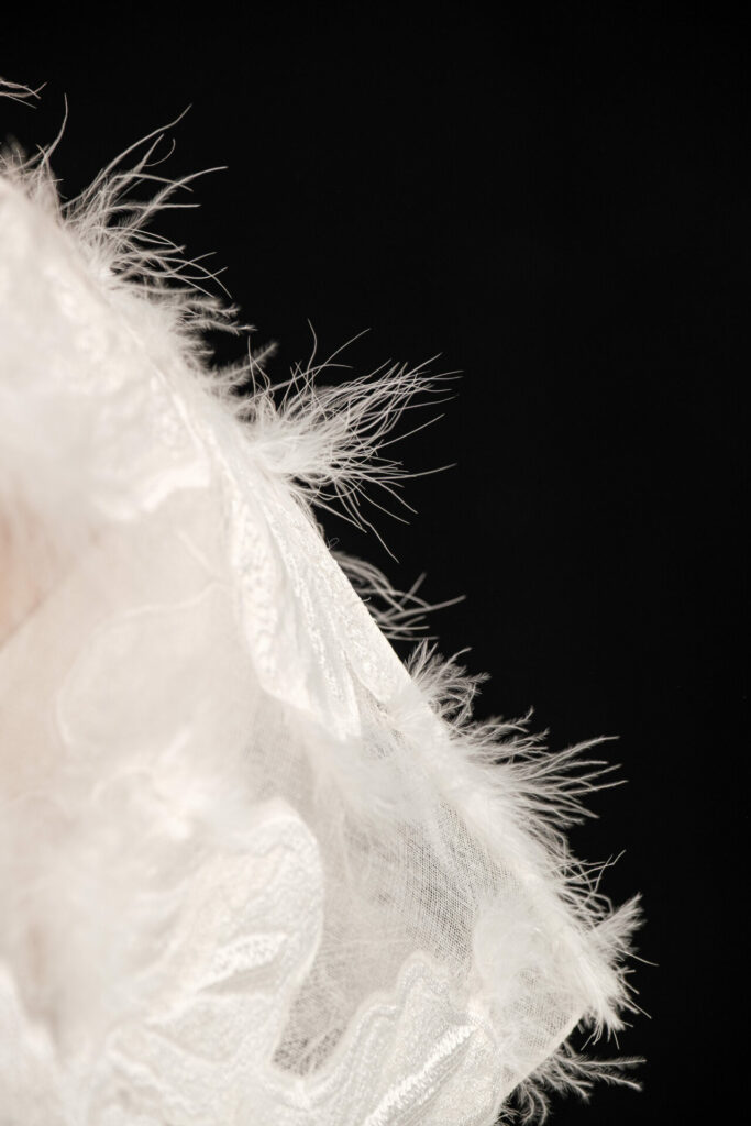 Sheer white fabric with feathered edge on black.