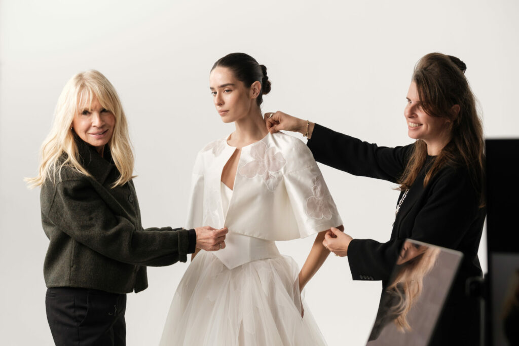 Mira Zwillinger atelier fitting SS2027 floral statement bridal cape on couture bride in Tel Aviv studio.