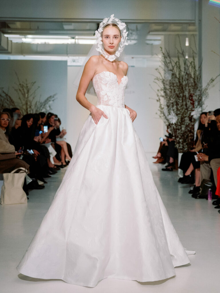 Model in strapless Clea wedding dress on runway.