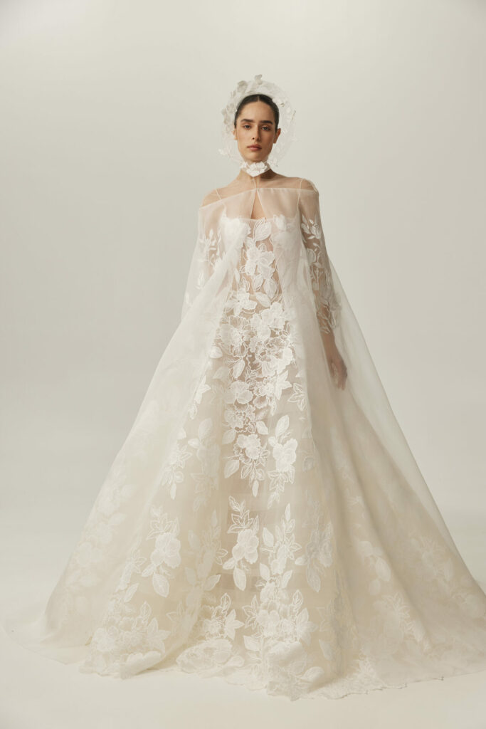 Woman in white lace Clea wedding dress, plain background.