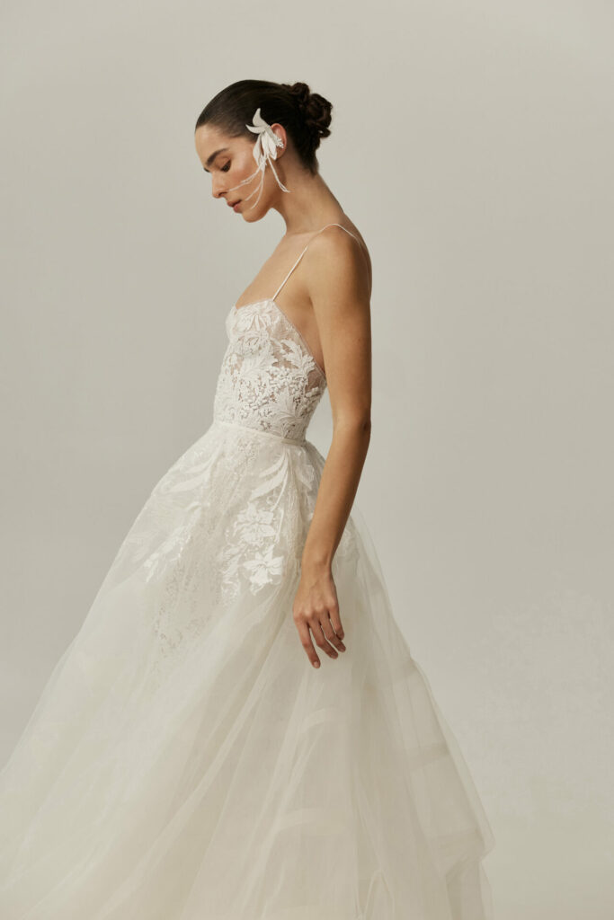 Bride in lace Clea dress, low bun, serene.
