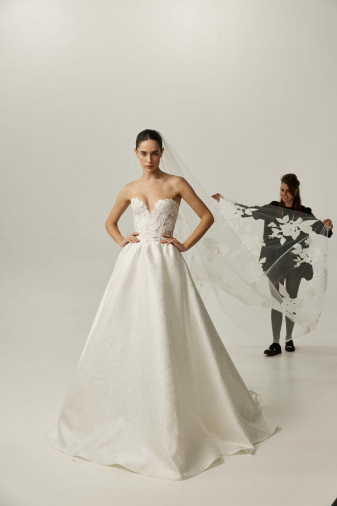 Mira Zwillinger SS2027 bride poses with handcrafted long floral couture bridal veil.