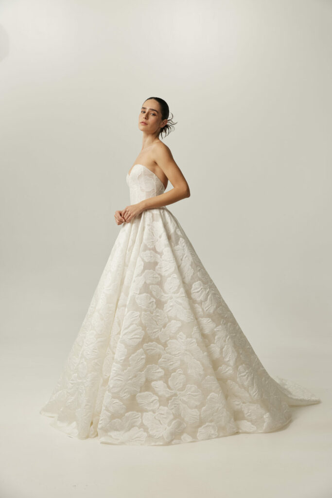 Woman in strapless floral gown, hair back, sideways.