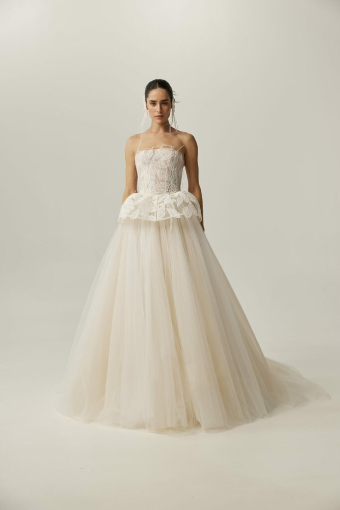 Woman in strapless white wedding gown with tulle skirt.