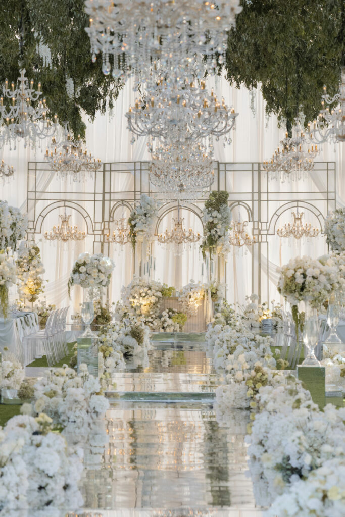 Luxurious wedding venue with white flowers and chandeliers.
