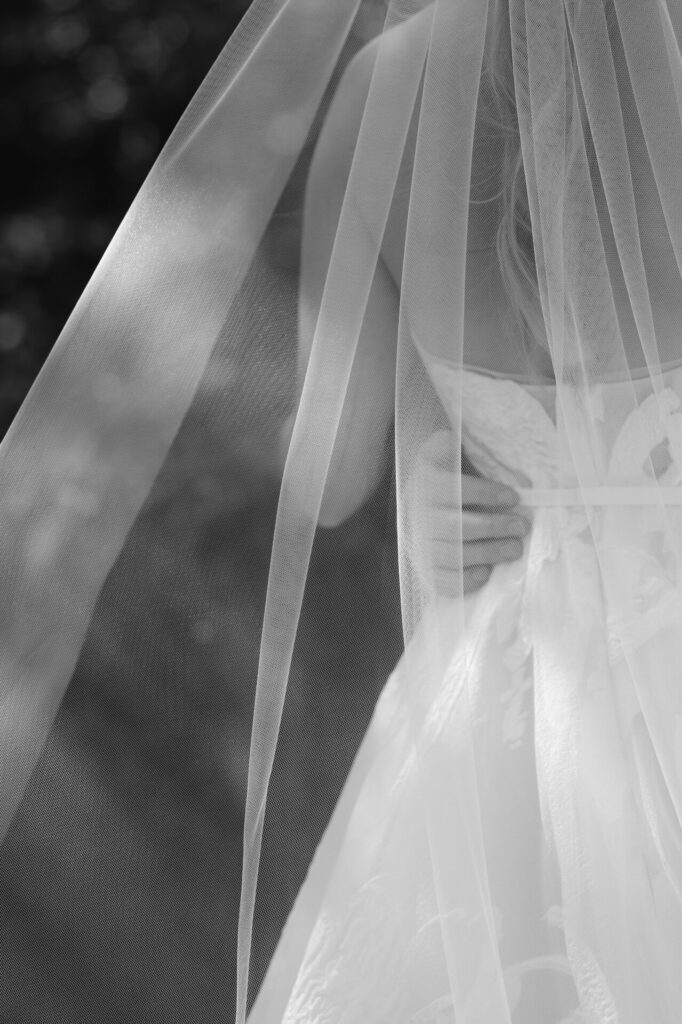 Katya Ruiz in couture dress, veil-draped, sunlit shadows.