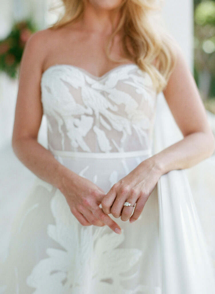 Katya Ruiz outdoors in sheer white leaf dress, showing ring.