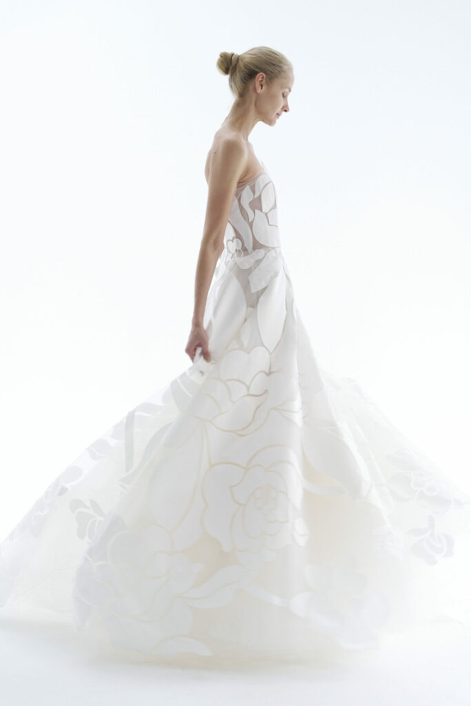 Woman in floral white ball gown, profile view.