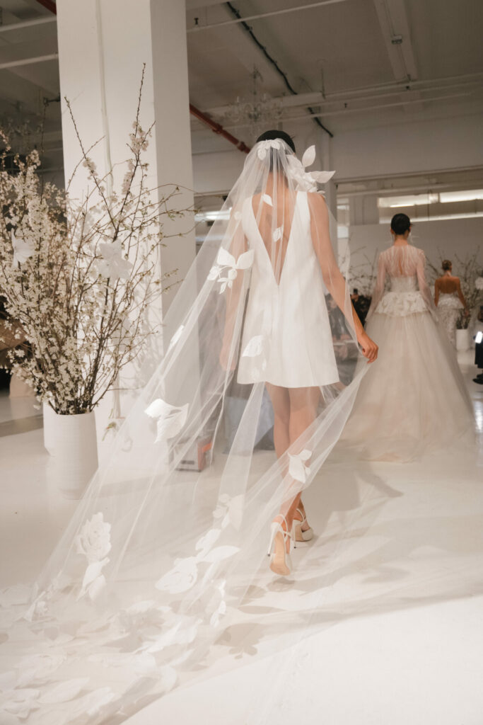 Model in short Clea dress, long floral veil.