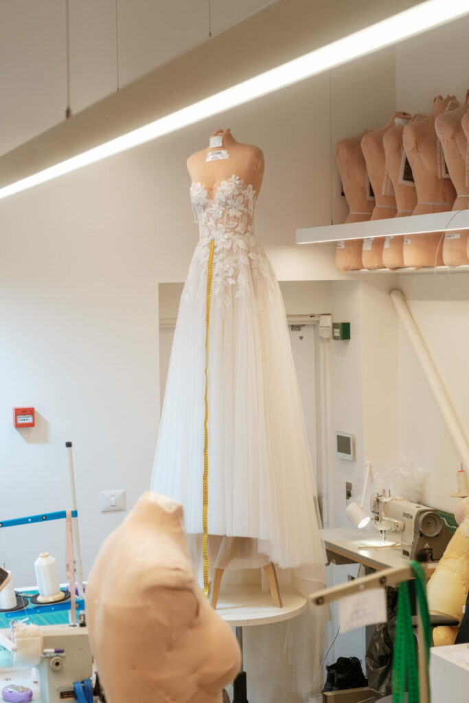 Wedding dress on mannequin with measuring tape, studio.