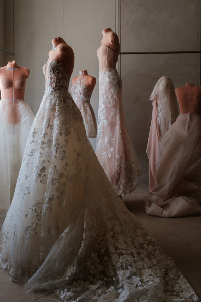 Lace wedding gowns on dress forms in studio.