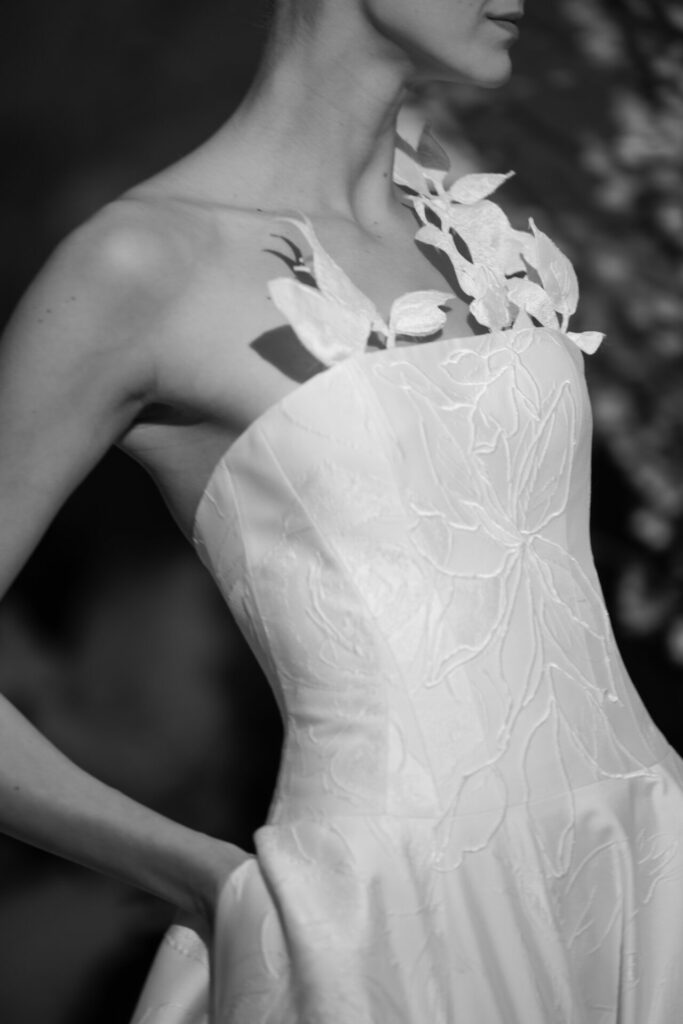 Woman in strapless embroidered wedding dress, black-and-white.