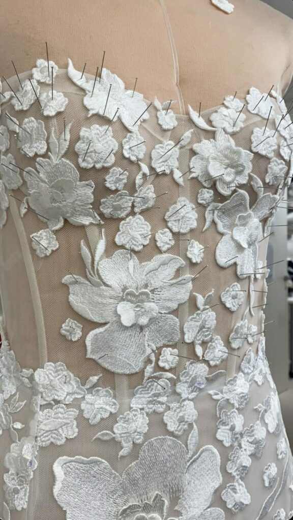 Sheer corset on dress form with white floral lace.