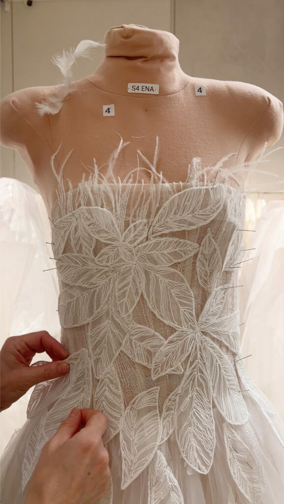 Adjusting embroidered white tulle dress on S4 ENA mannequin.