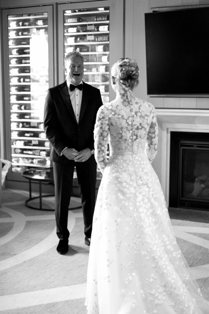 Groom laughs seeing bride in Clea dress.