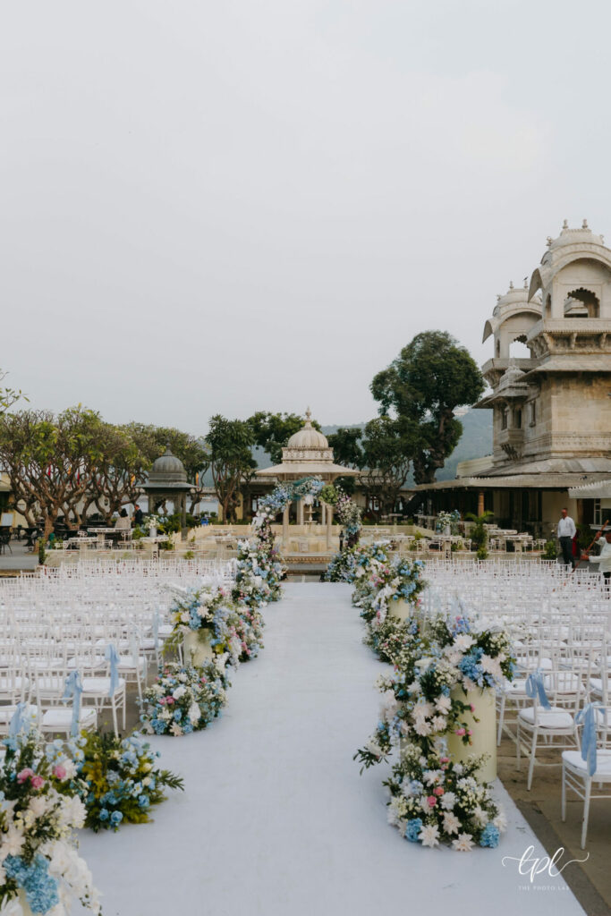 Elegant outdoor wedding with floral aisle and stone arches.