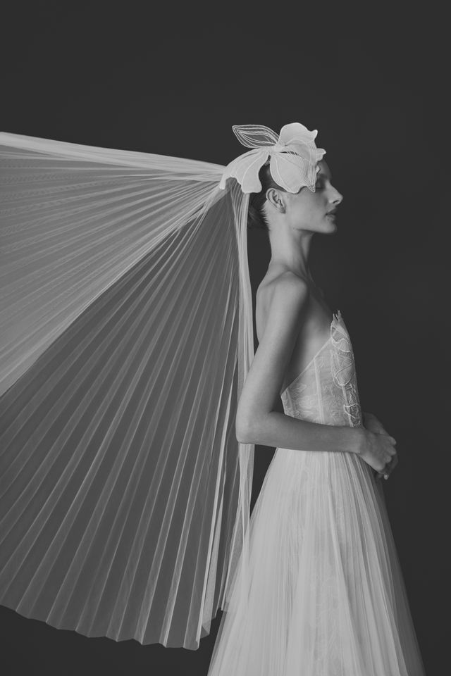 Woman in sheer gown, floral headpiece, dramatic veil, black and white.