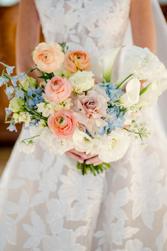 Katya Ruiz in white lace bridal dress with colorful bouquet.