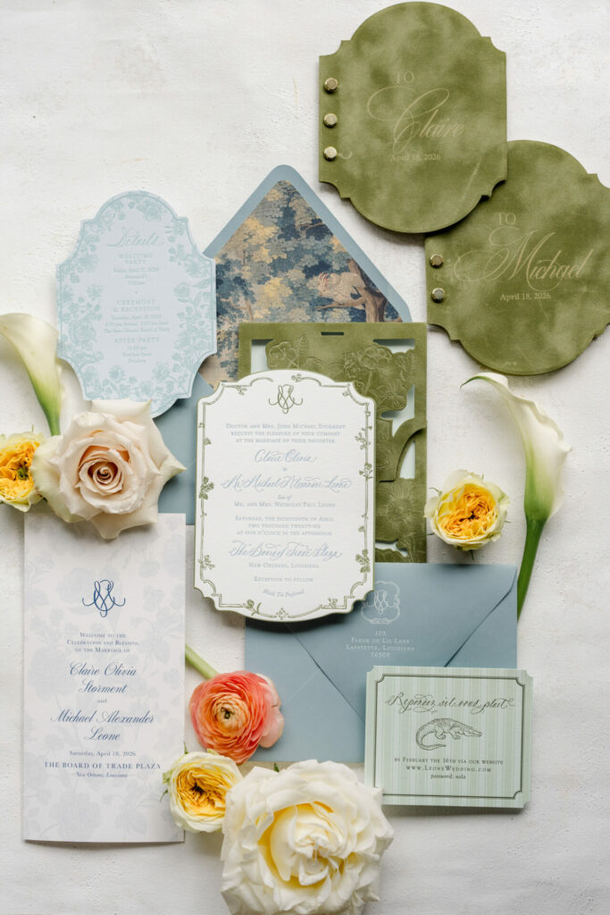Elegant green, blue, and white wedding invites with flowers.
