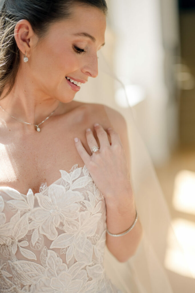 Bride in luxe Mia Hinkebein dress gazes down, smiling.