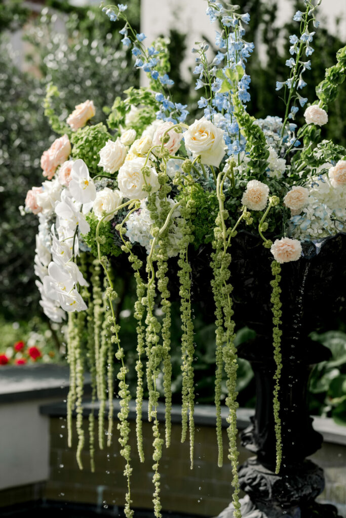 Ornate black vase with elegant floral bouquet outdoors.