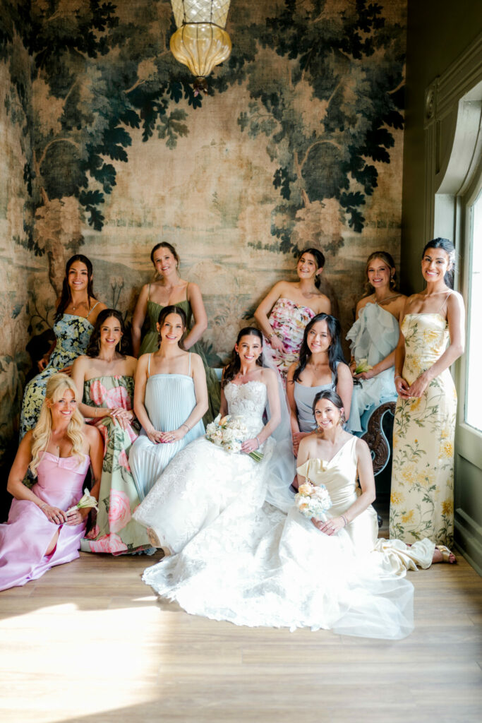 Bride with eleven bridesmaids posing by vintage mural.