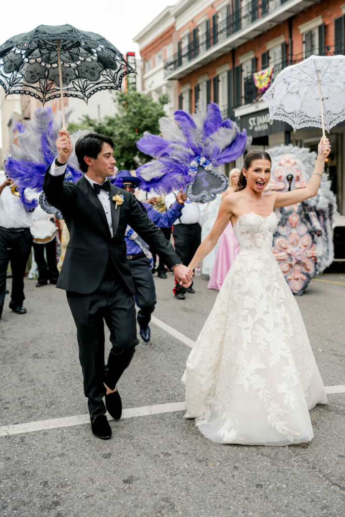 Katya Ruiz and groom lead street parade, dancers follow.