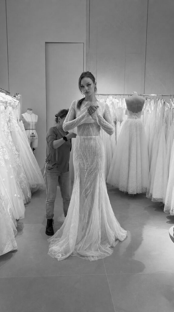Bride trying on the sheer Anouka wedding dress in the Mira Zwillinger atelier