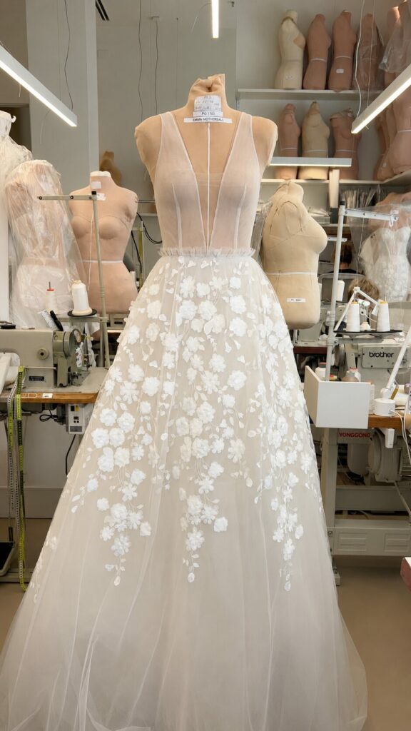Floral embroidered wedding gown on dress form.