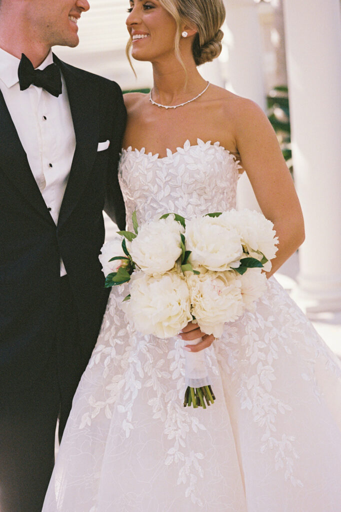 Elegant bride and groom smiling at each other.