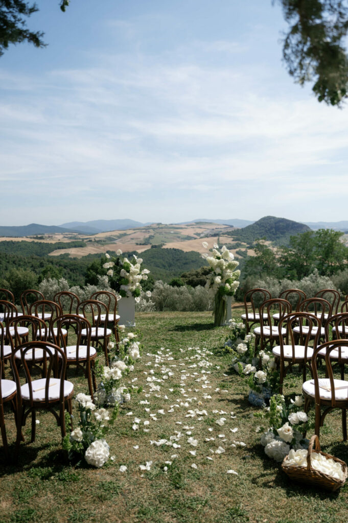 Elegant outdoor wedding with flowers and rolling hills.
