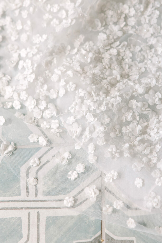 White 3D floral lace draped on blue pattern.