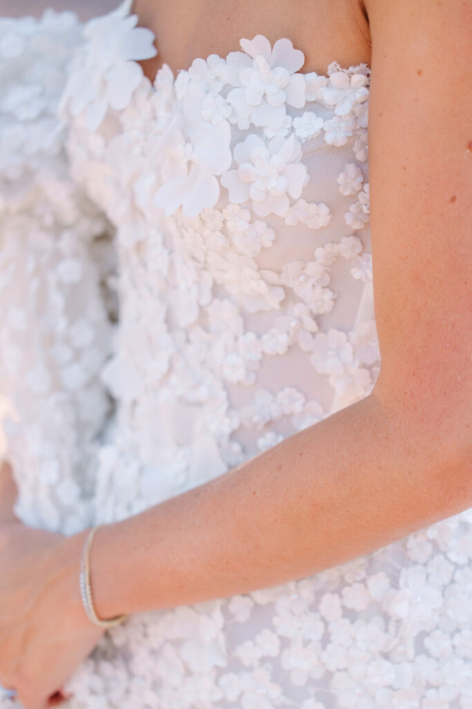 White strapless dress with 3D floral appliqués.