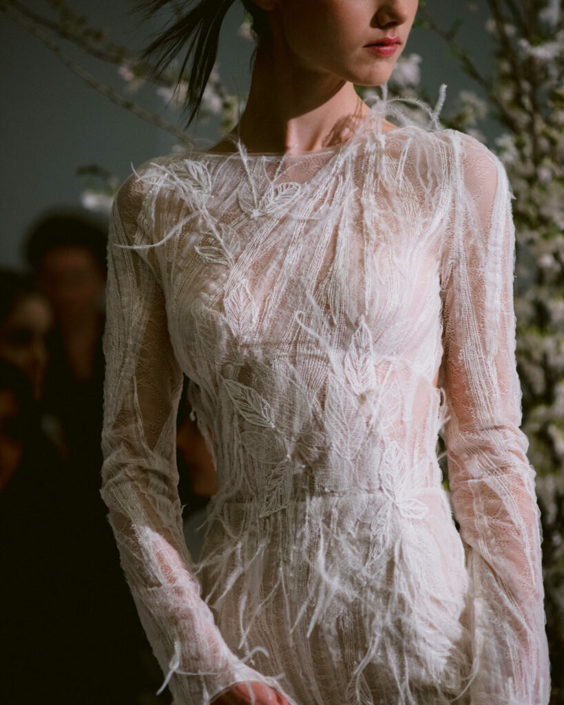 Model wearing the sheer embroidered long-sleeve Anouka wedding dress by Mira Zwillinger