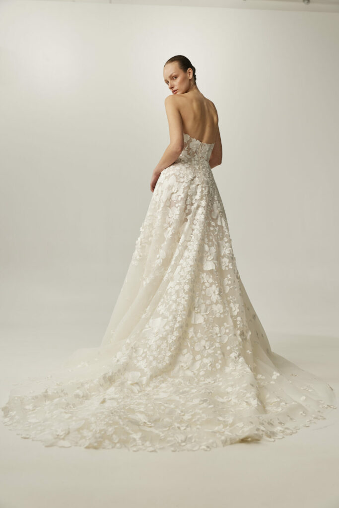 Bride in the strapless Alma A-line wedding dress by Mira Zwillinger with a floral train