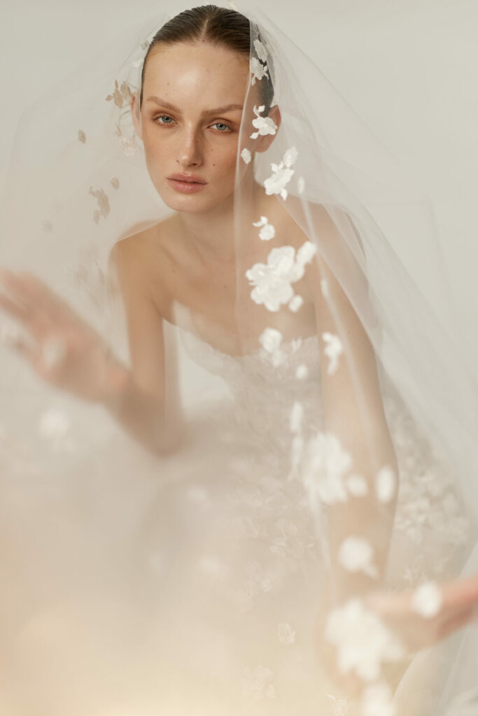 Bride in the Alma wedding dress by Mira Zwillinger beneath a sheer veil