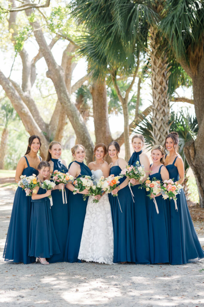 Bride and bridesmaids outdoors in elegant dresses.