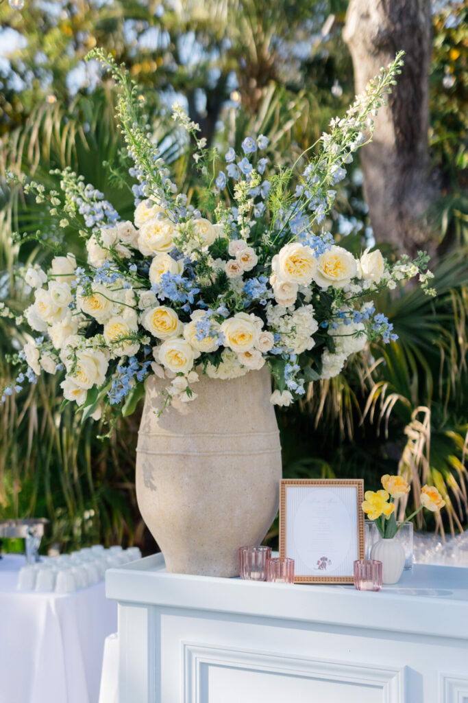 Elegant floral centerpiece on outdoor white table.