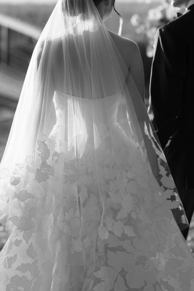 Bride in floral veil, luxury black and white scene.