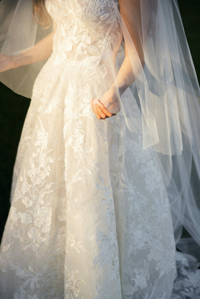 Katya Ruiz in lace wedding dress, sunlight on veil.
