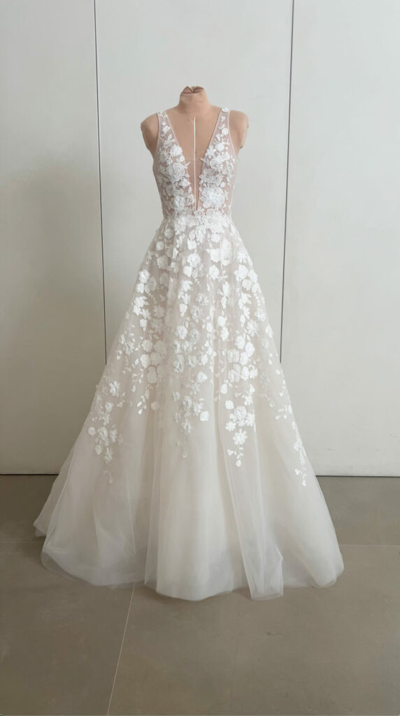 Luxury lace bridal gown with deep V, displayed.